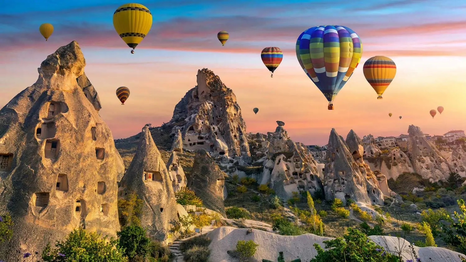 Tourist using StayinWifi pocket WiFi inside hot air balloon basket over Cappadocia fairy chimneys at sunrise – unlimited 5G connection